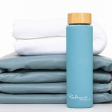 Bambusflaske lokk med trekk, håndkle og sammenlagt matte. Praktisk sett for hydrering og spa-opplevelse hjemme.