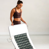 Kvinne viser hvor enkelt det er å brette sammen Radiant Health infrarød matte.