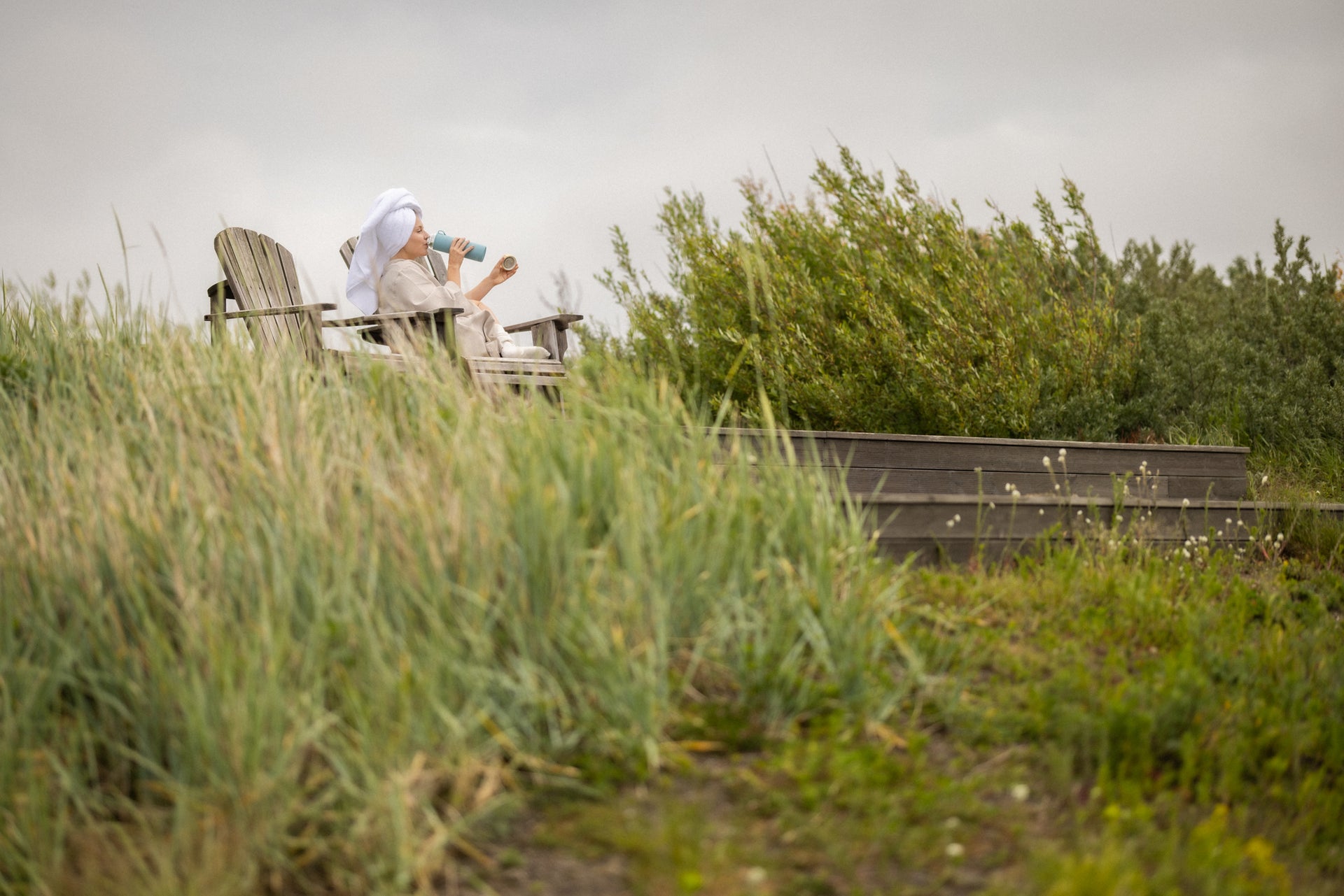 Avslapping ute med kopp og Radiant Health flaske, nyt varme og velvære i frisk luft.