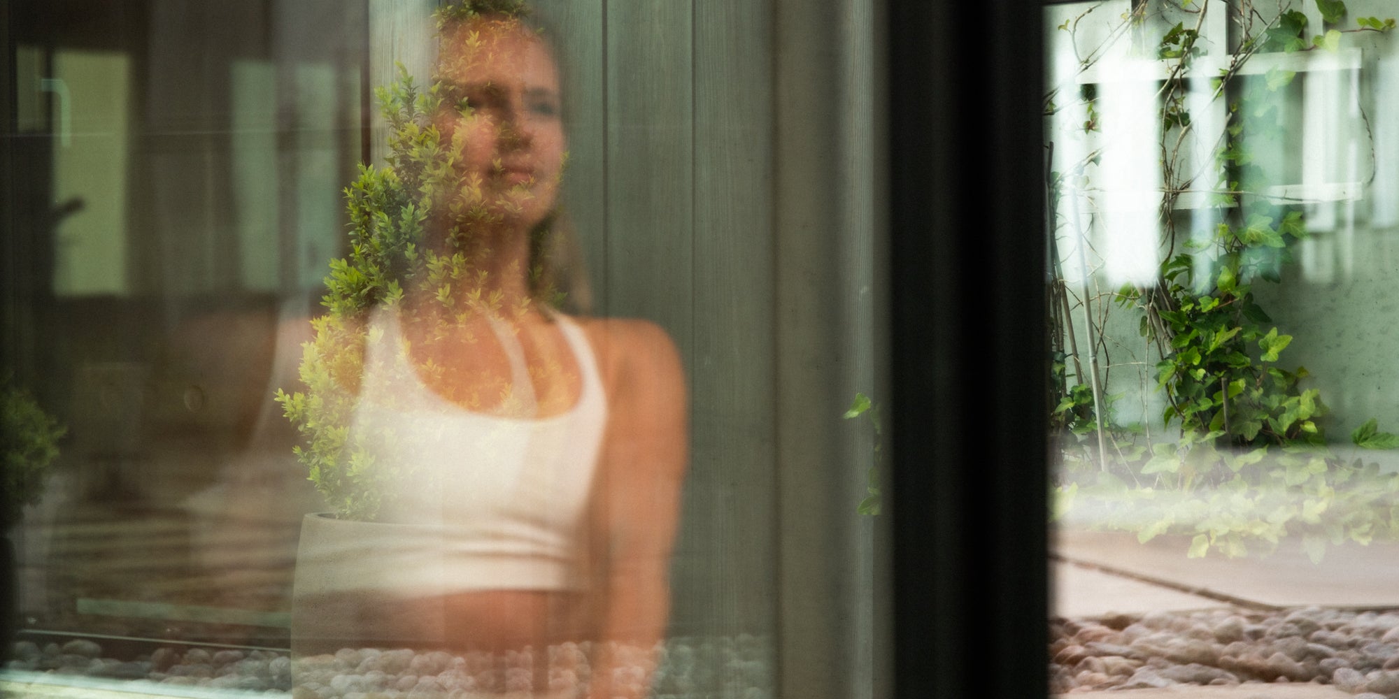 Kvinne etter sittesauna med infrarød varme – rolig hjemmespa med grønne planter