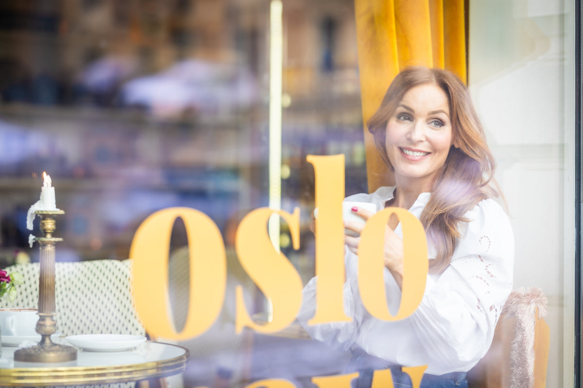 Kvinne nyter en kopp kaffe på oslo raw – varme øyeblikk og livsglede.