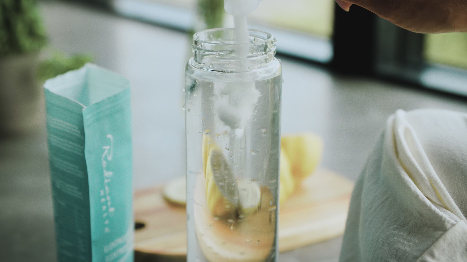 Tilsetter Radiant Health elektrolyttpulver  i vann med sitron for naturlig hydrering og mineralbalanse.