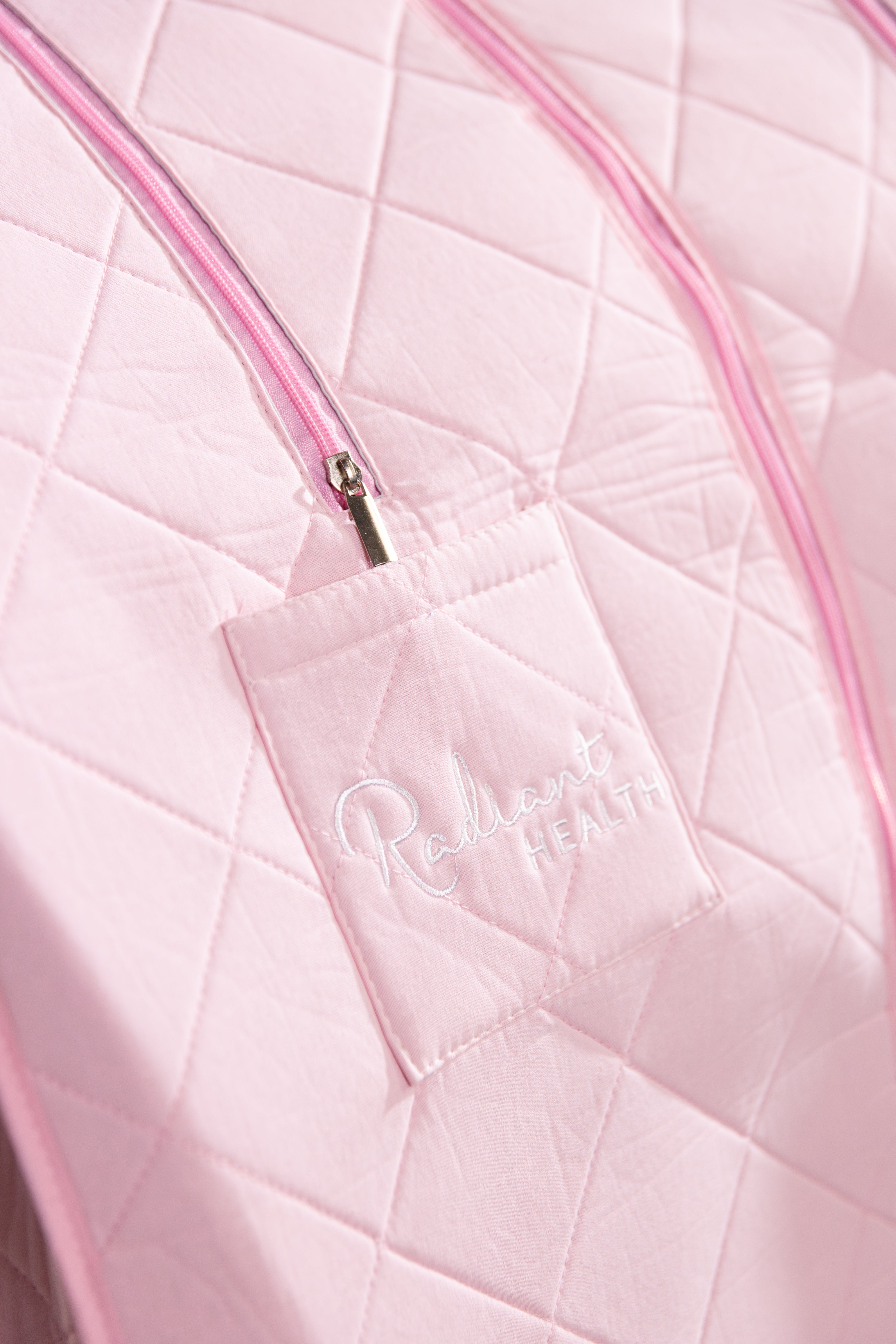 Nærbilde av Radiant Health-logo og detaljer på rosa infrarød sauna.