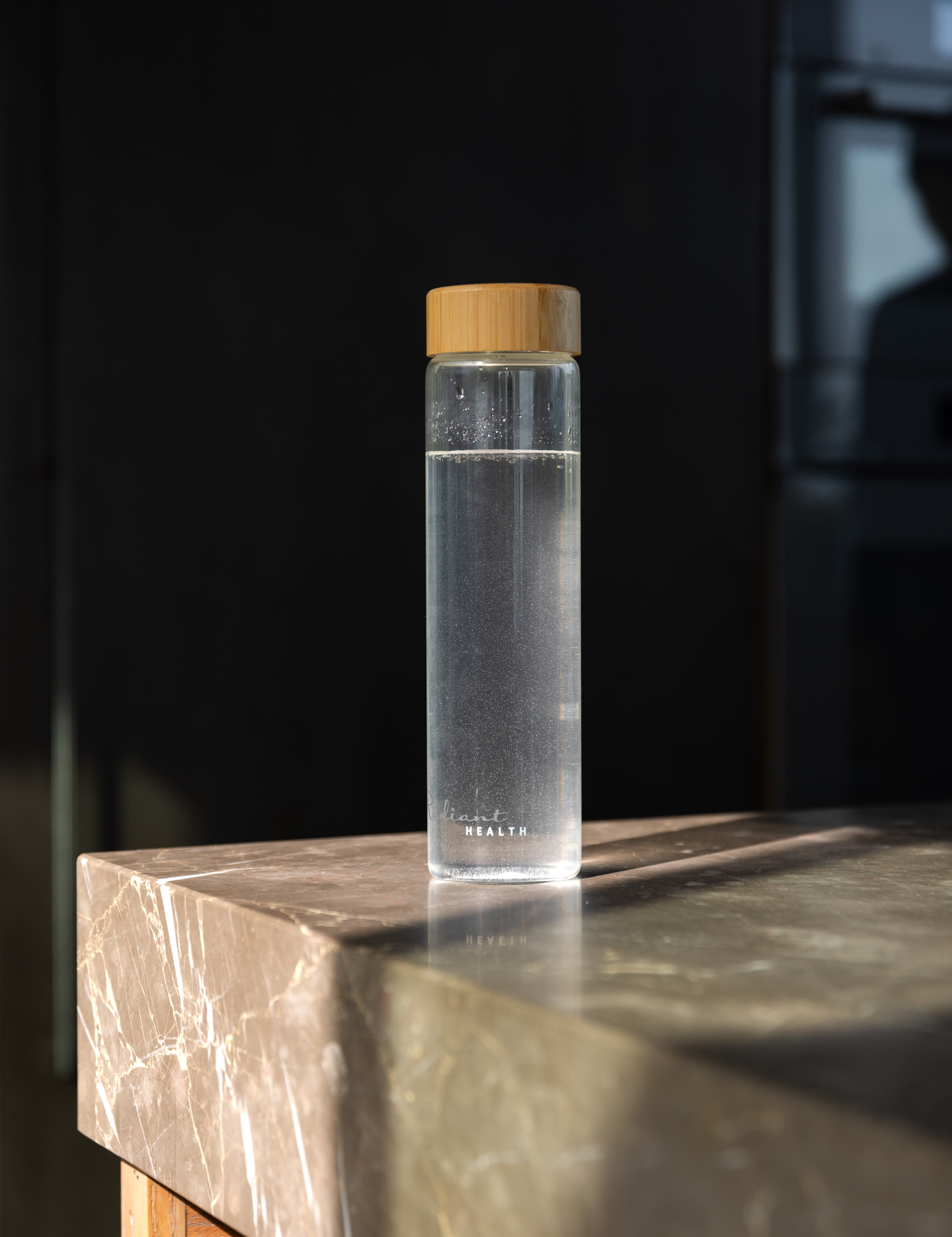 Minimalistisk glassflaske med naturinspirert lokk. Miljøvennlig og funksjonell design.