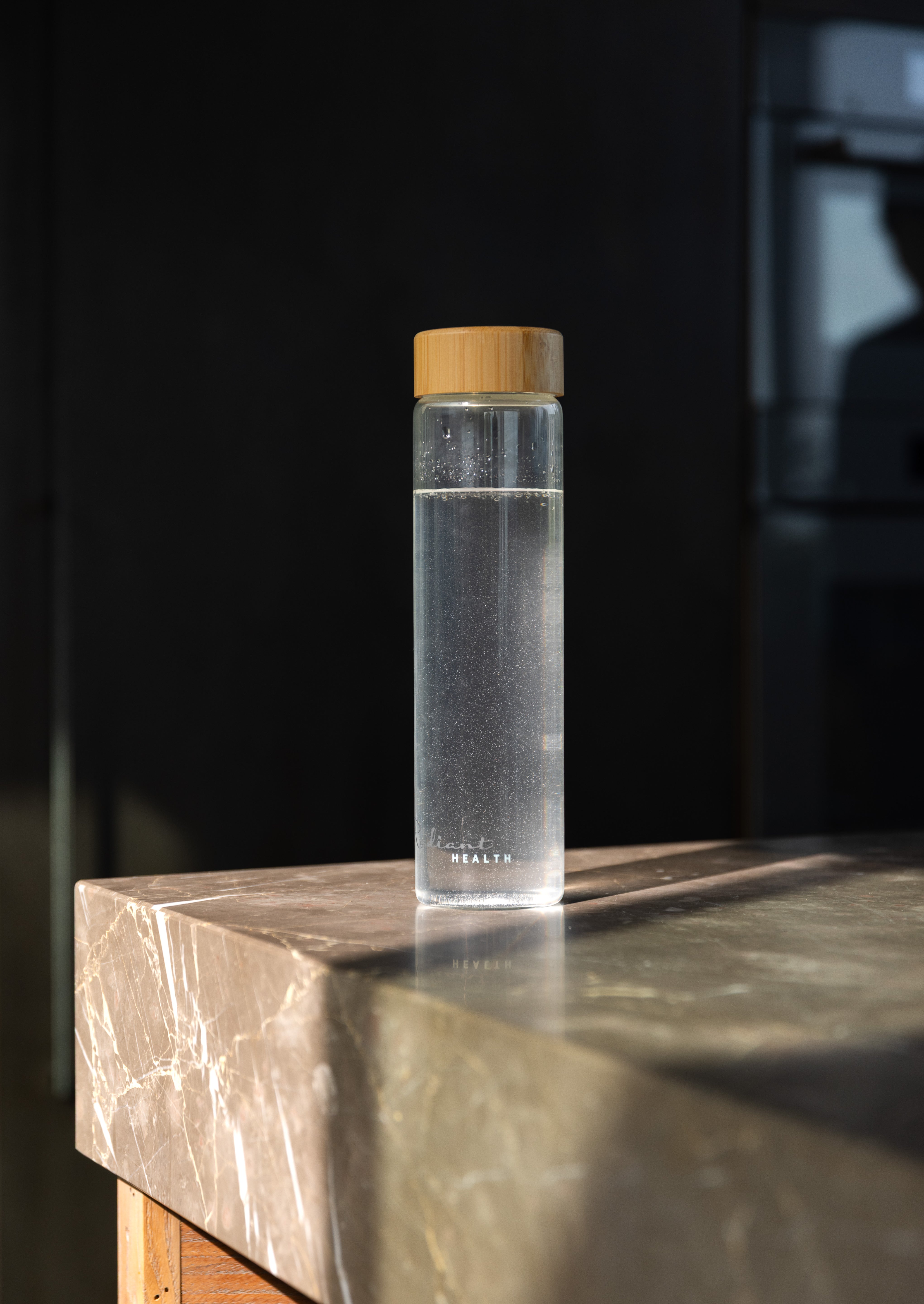 Minimalistisk glassflaske med naturinspirert lokk. Miljøvennlig og funksjonell design.