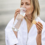 Elegant vannflaske i glass fra Radiant Health, perfekt etter sauna eller trening.