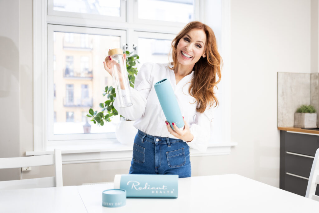 Kvinne viser frem Radiant Healths glassflaske